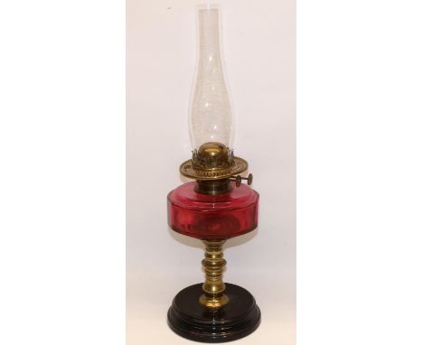C19th brass oil lamp with cranberry glass reservoir and black base, with chimney, lacking shade, H31cm excl. chimney 
