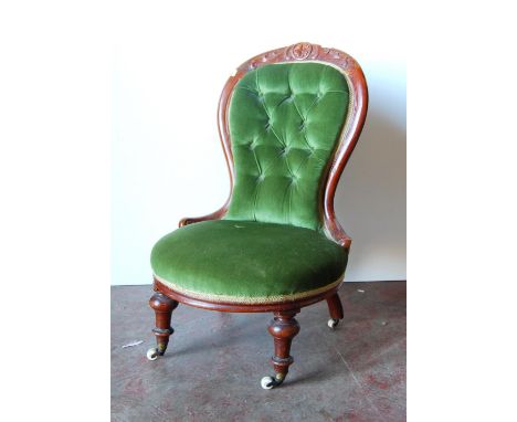 Victorian mahogany lady's button-back chair with foliate carved rail over oval seat, raised on baluster turned legs terminati