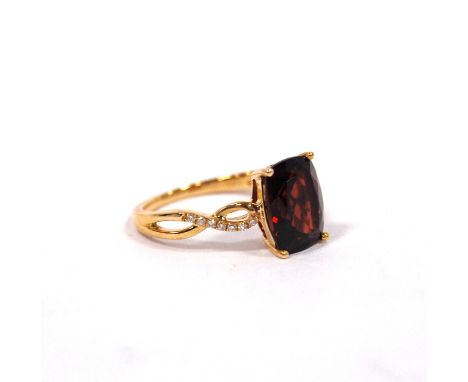 Dress ring with almandine garnet of bowed shape between diamond-set shoulders, in gold, '14k', size K½, boxed, and cased.COND