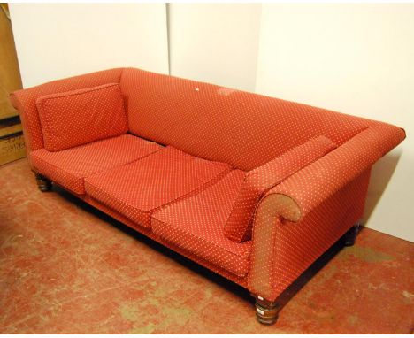 Large sofa with cushioned back and scroll arms, loose cushioned seat, raised on turned legs, 225cm wide, 70cm high, and 100cm