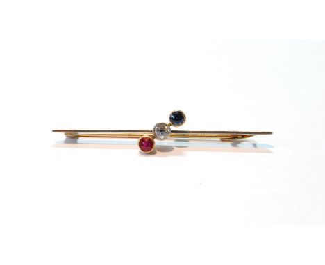 Early 20th century brooch with a diamond, a sapphire, and a ruby, collet-set diagonally upon a bar, gold and platinum, 1.7g. 