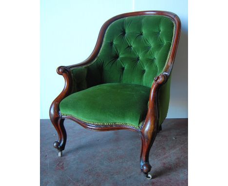 Victorian mahogany button-back chair with downswept arms, serpentine seat, raised on cabriole legs terminating in ceramic cas