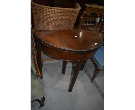 An early 20th Century mahogany demi lune fold over card table