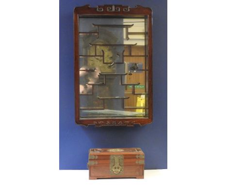 A Chinese hardwood wall mounted display cabinet, 20th century, with mirror back and arrangement of asymmetrical shelves, the 