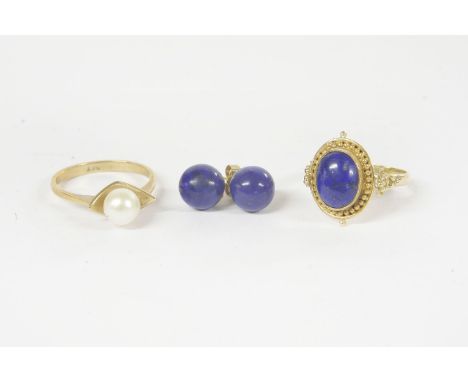 A gold single stone lapis lazuli cabochon ring, marked 585, a pair of lapis lazuli stud earrings, a single stone cultured pea