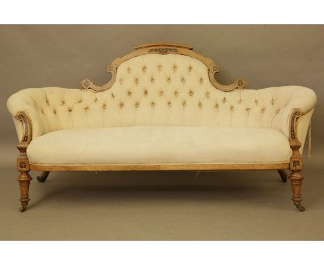 A Victorian walnut and inlaid cream button upholstered settee, turned legs and brass casters, 185cm wide x 90cm x 92cm