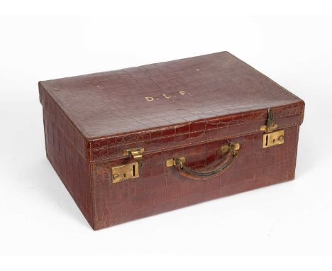 A crocodile skin dressing case by Finnigans, initialled to lid, containing silver mounted bottles and jars, 51cm wide, 36cm d