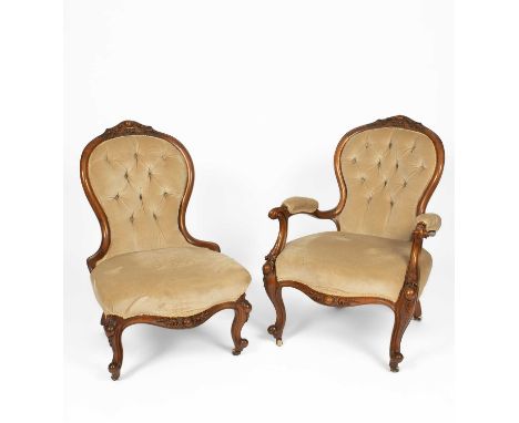 A near pair of Victorian walnut framed fireside chairs, with button upholstered backs and carved frames on white ceramic cast