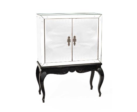 A drinks cabinet with mirrored exterior, cupboard doors decorated etched scrolling design, the interior fitted shelves, on st