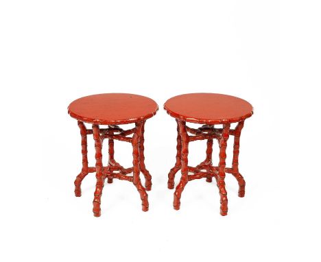 A pair of coral red painted occasional tables 20th Century, the circular tops with a carved segmented edge, on similar carved