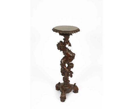 A carved and stained Italian-style torchère, the column of grotesque beast form, on a tripod base, 43cm diameter, 121cm high
