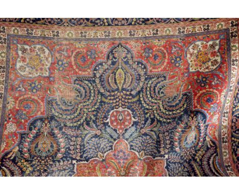 A large Caucasian woollen carpet, or possibly Asfahan, in red and blue with ornate patterns, approx 400cm by 300cm, some wear