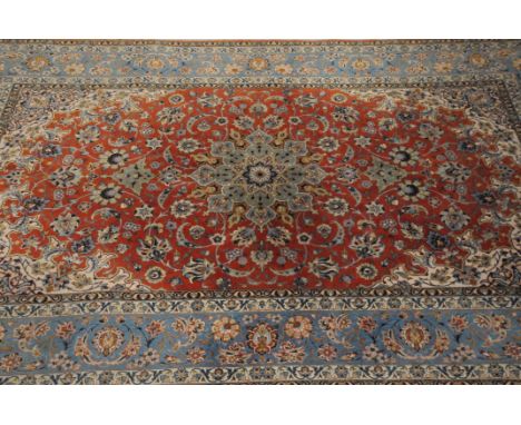 A modern Iranian silk carpet, light blue and coral ground with ornate designs, signed to one end, 225cm by 148cm