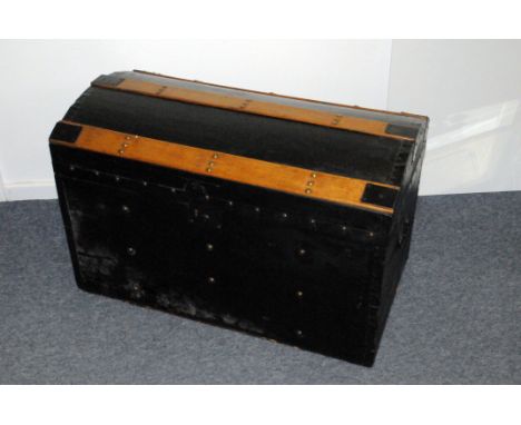 A vintage travel trunk, black painted with wooden struts to top, opening to reveal lift out tray