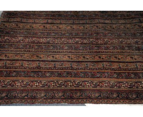 A late 19th or early 20th century Middle Eastern carpet, the finely woven runner style rug having unusual strips of scrolling