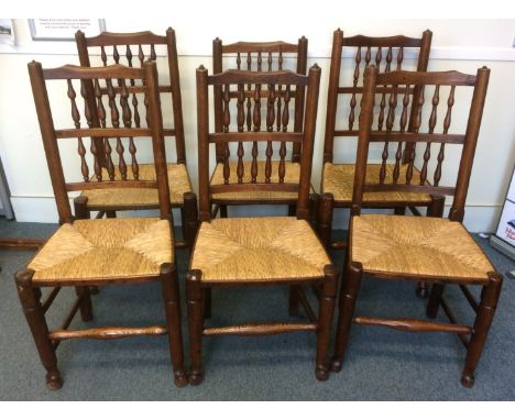 A set of six antique elm ladder back chairs, with spindled decorations to the backs and rushed seats (6) 