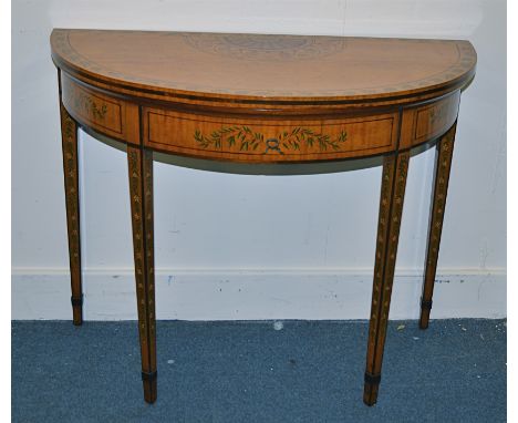 An Edwardian period Sheraton revival satinwood painted demi lune card table decorated with floral and foliate design and rose