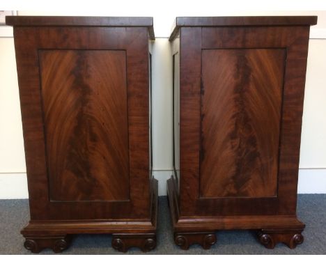 A pair of Willian IV mahogany pedestal cabinets, each with a figured mahogany panelled door and side panels, one shelf to the