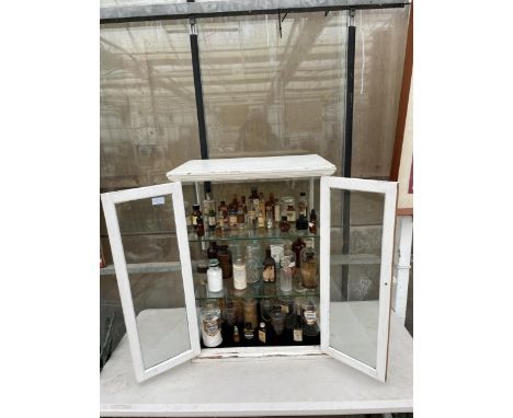 A VINTAGE APOTHECARY CABINET CONTAINING A LARGE ASSORTMENT OF VINTAGE GLASS MADICINE BOTTLES 