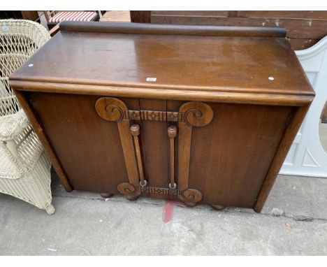 AN OAK ART DECO SIDEBOARD, 48" WIDE WITH LONG DROP TURNED TWIN HANDLES 