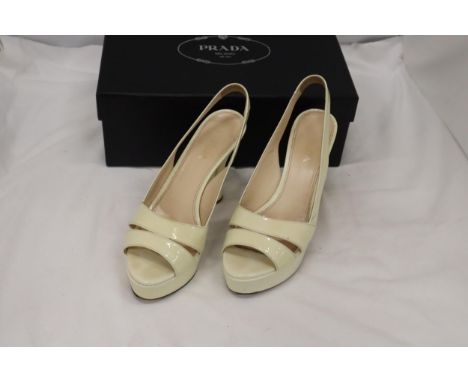 A PAIR OF CREAM HIGH HEELED SHOES, MARKED WITH A GOLD COLOURED 'PRADA' TO THE UNDERSIDE, IN A BOX MARKED 'PRADA', SIZE 37, IN