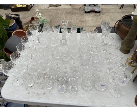 A LARGE QUANTITY OF CUT GLASS WARE TO INCLUDE WINE GLASSES, WHISKEY GLASSES AND BRANDY BALOONS ETC 