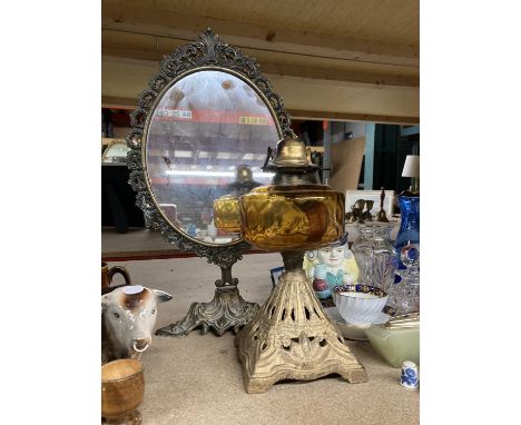 A VINTAGE OIL LAMP WITH AMBER GLASS RESERVOIR AND A DECORATIVE DRESSING TABLE MIRROR 