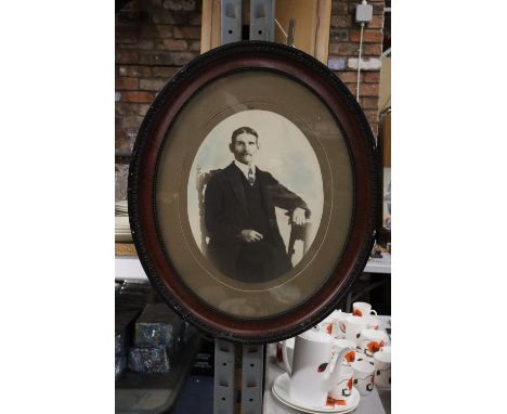 A VINTAGE OVAL FRAMED PHOTOGRAPHIC PRINT OF A MAN 