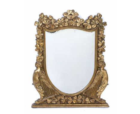 AN IRISH GILT WOOD AND GESSO MOULDED MIRROR with later shield shaped bevelled mirror plate, the mirror decorated with clover 