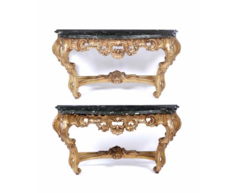 A PAIR OF LOUIS XV STYLE MARBLE TOPPED CARVED GILTWOOD CONSOLE TABLES with serpentine marble top and acanthus leaf flower hea