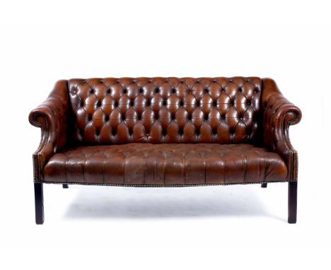 A GEORGIAN STYLE BUTTON BACK LEATHER UPHOLSTERED SOFA with scrolling arms and studded details, 78cm x 71cm x 155cm