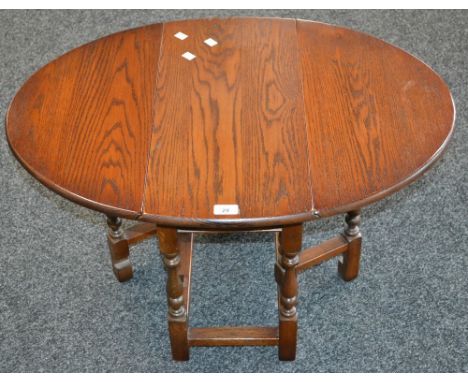 An Old Charm oak dropleaf occasional table, model 1493, oval top. 47.5cm high x 59.5cm wide x 31cm opening to 82cm.