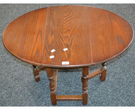 An Old Charm oak dropleaf occasional table, model 1493, oval top. 47.5cm high x 59.5cm wide x 31cm opening to 82cm.
