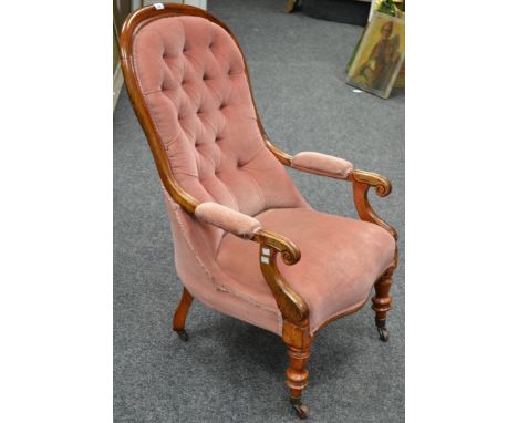 A Victorian mahogany button back armchair, turned scroll arms, turned legs, ceramic casters, in pink velvet upholstery, 105cm