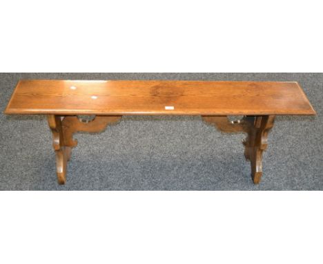 An oak bench, moulded rectangular top, shaped end supports. 46cm high x 137cm long x 27cm wide .