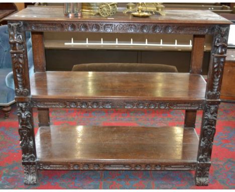 An oak three tier buffet, moulded tiers, the friezes carved with floral roundels,  caryatids to uprights.