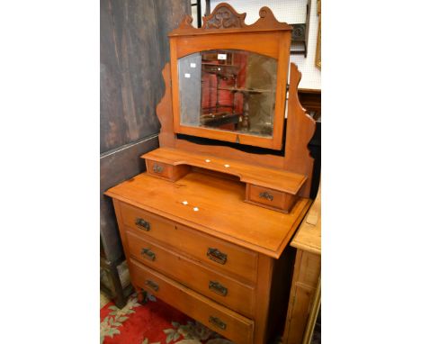 A satinwood dressing table, shaped and carved pediment to arched mirror, two short drawers and shelf to superstructure, three