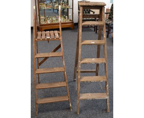 Two sets of vintage wooden step ladders, one six step, the other seven