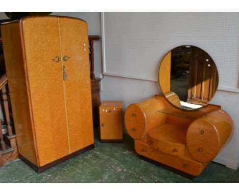 An Art Deco birds-eye maple bedroom suite comprising fitted gentleman's wardrobe, dressing table, circular mirror over glass 