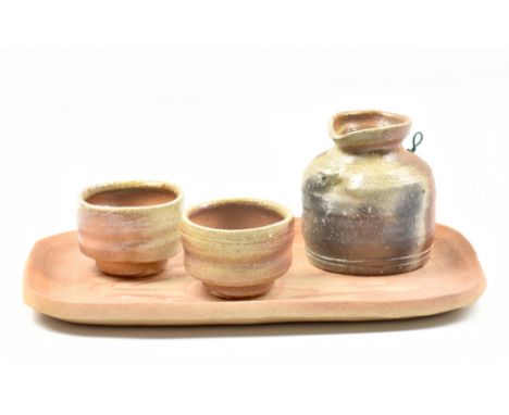 MASANOBU IZUMIHARA; an anagama fired stoneware sake set comprising jug, pair of cups and rectangular tray, impressed and inci