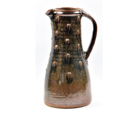 JIM MALONE (born 1946); a tall stoneware jug with finger dab decoration covered in tenmoku breaking to kaki glaze, impressed 