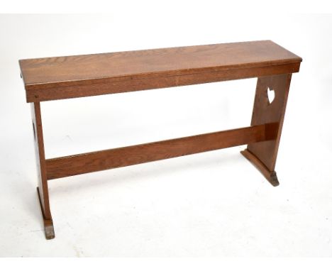 An Arts and Crafts carved oak bench with carved love heart side panels, length 118cm.