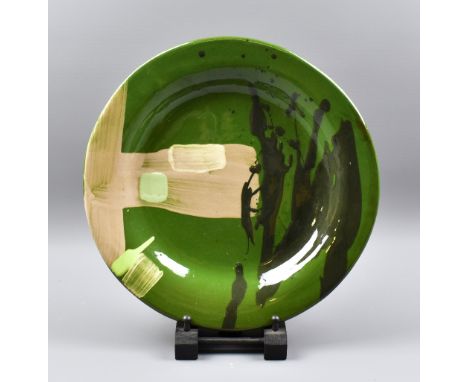 BRUCE McLEAN (born 1944); a large earthenware plate with brush and trailed decoration on green ground, painted signature and 