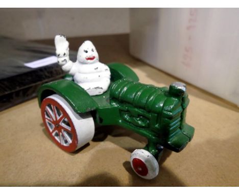 Cast iron Michelin Man on a tractor, H: 12 cm. UK P&amp;P Group 1 (£16+VAT for the first lot and £2+VAT for subsequent lots) 