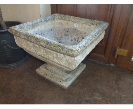 A LARGE SQUARE STONE PLANTER ON BASE