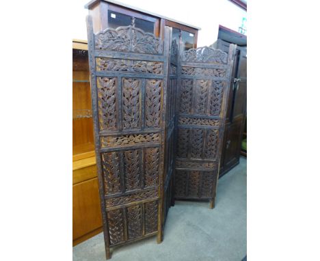 An Indian carved hardwood four panel folding dressing screen 