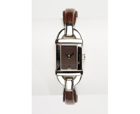 LADY'S GUCCI BANGLE WATCH
in stainless steel, the brown rectangular dial without numerals, on a stainless steel and brown lea