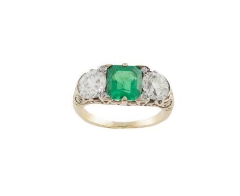 A diamond and emerald ring, composed of a rectangular step-cut emerald between old round brilliant-cut diamonds within a scro