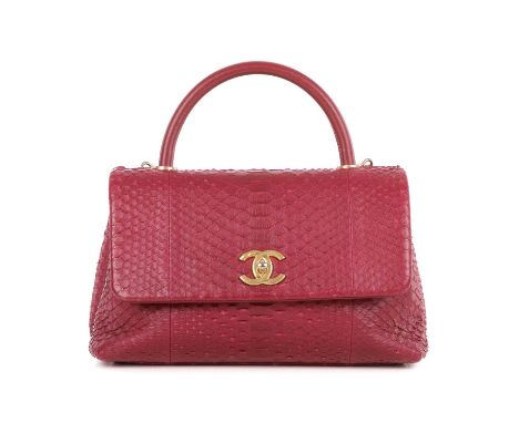 Chanel, a Coco Handle python handbag, crafted from pink python skin, featuring brushed gold-tone hardware, a looping leather 