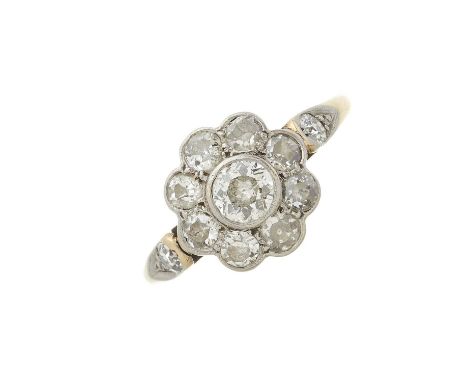 An early 20th century 18ct gold and platinum, old-cut diamond floral cluster ring, with similarly-cut diamond accent shoulder